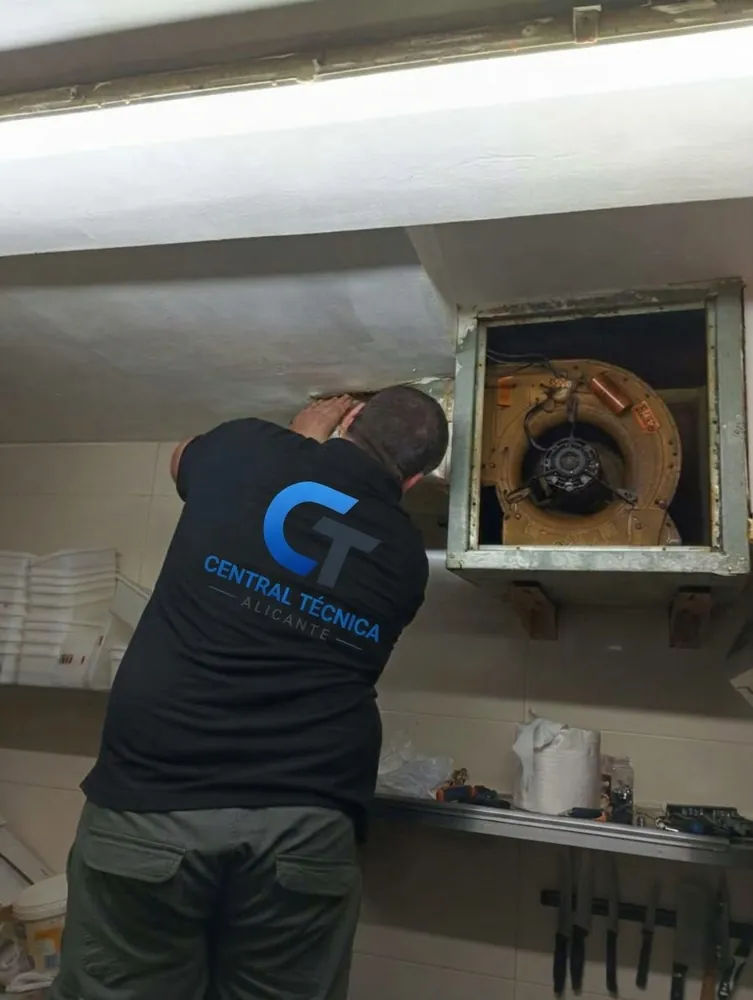 Técnico de Central Técnica Alicante cambiando el condensador del motor de extracción de una campana en una cocina de San Juan