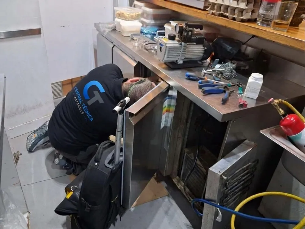 Técnico de Central Técnica Alicante con bomba de vacío y refrigerante reparando una fuga de gas en una cámara frigorífica de Santa Pola